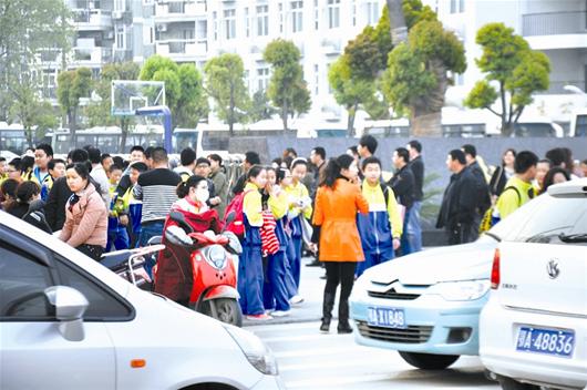圖為：放學(xué)后，很多家長開車接孩子回家