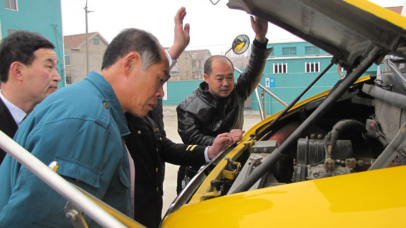 檢車人員正在查看校車發動機是否正常
