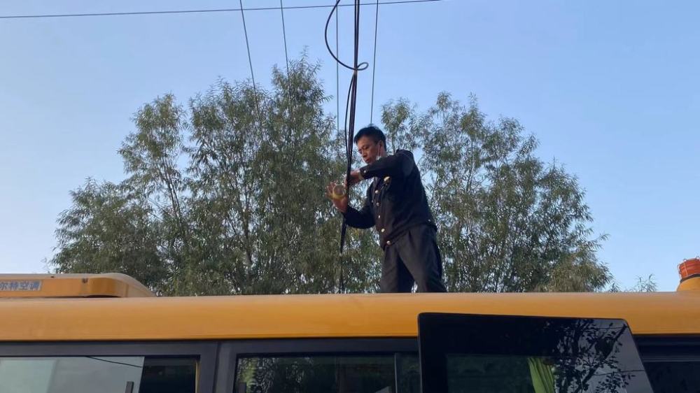 電纜下墜阻礙交通 溫馨校車司機(jī)迅速清障